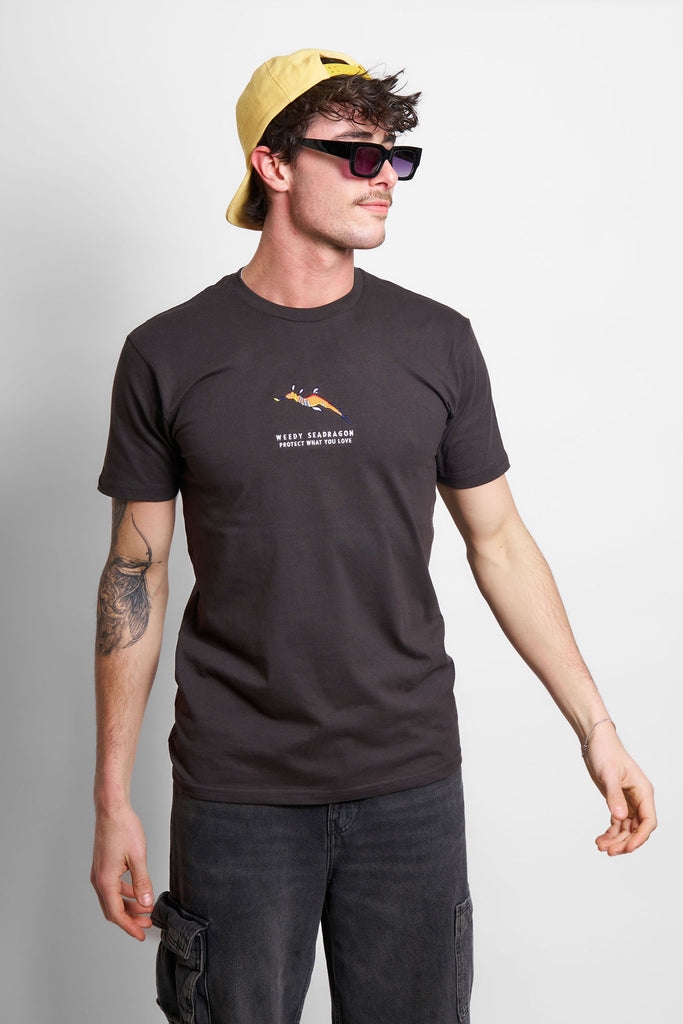 Male model wearing a Charcoal t-shirt with a weedy seadragon design and the Protect What You Love text.